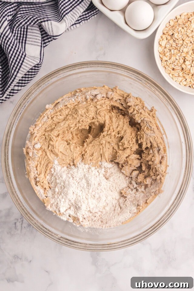 overhead view of dry ingredients added to cookie dough
