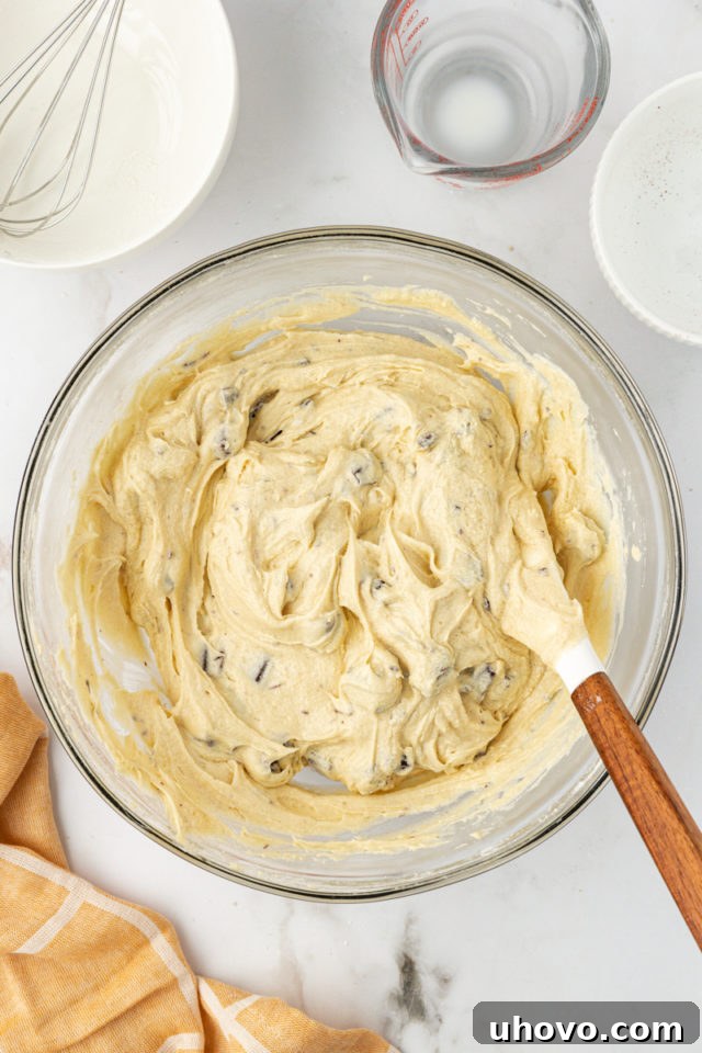 overhead view of mixed chocolate chunk cupcake batter in a glass mixing bowl
