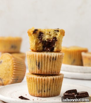 a stack of three chocolate chunk cupcakes with a bite missing from the top cupcake to show the chocolate filling and soft texture