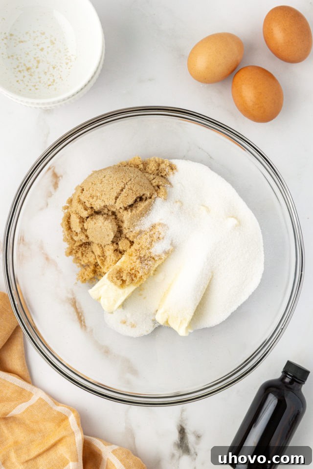 overhead view of butter, sugar, and brown sugar in a glass mixing bowl