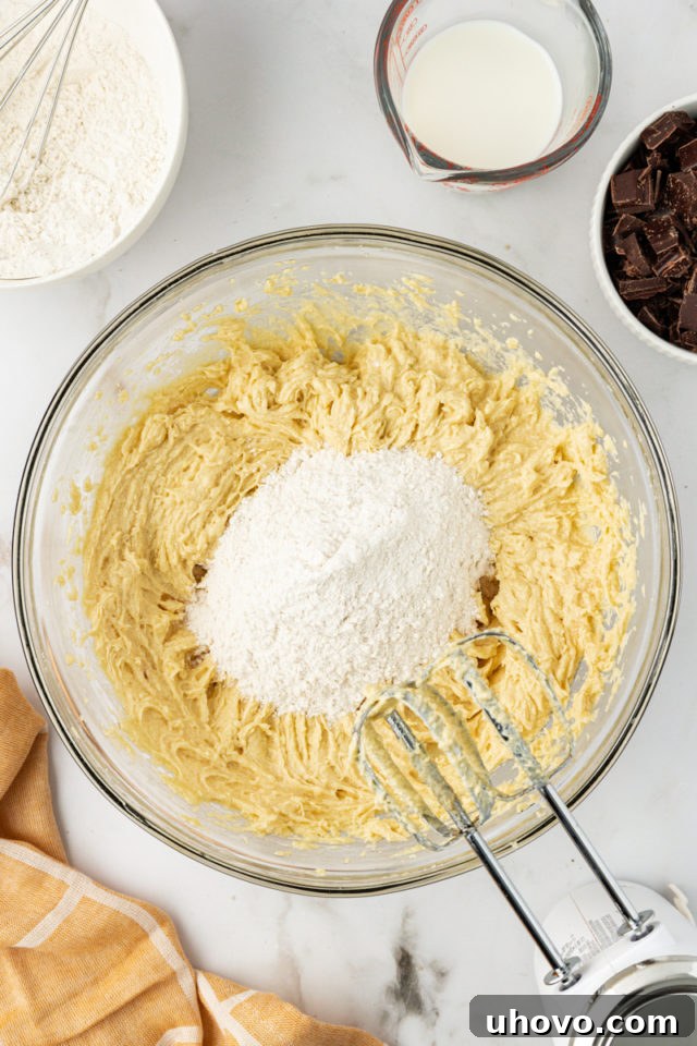 overhead view of dry ingredients added to creamed ingredients for chocolate chunk cupcakes