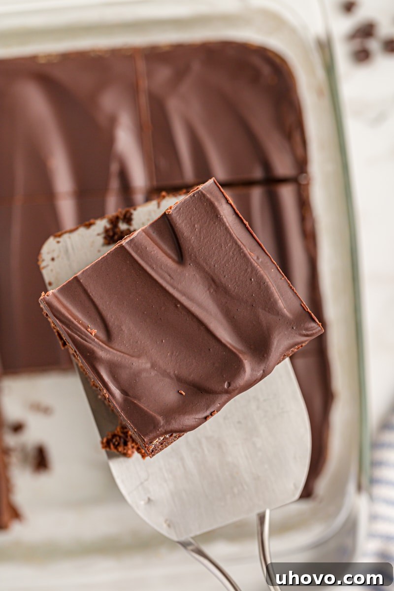 A spatula lifting a perfect slice of chocolate mascarpone brownie from the pan, ready to be served.