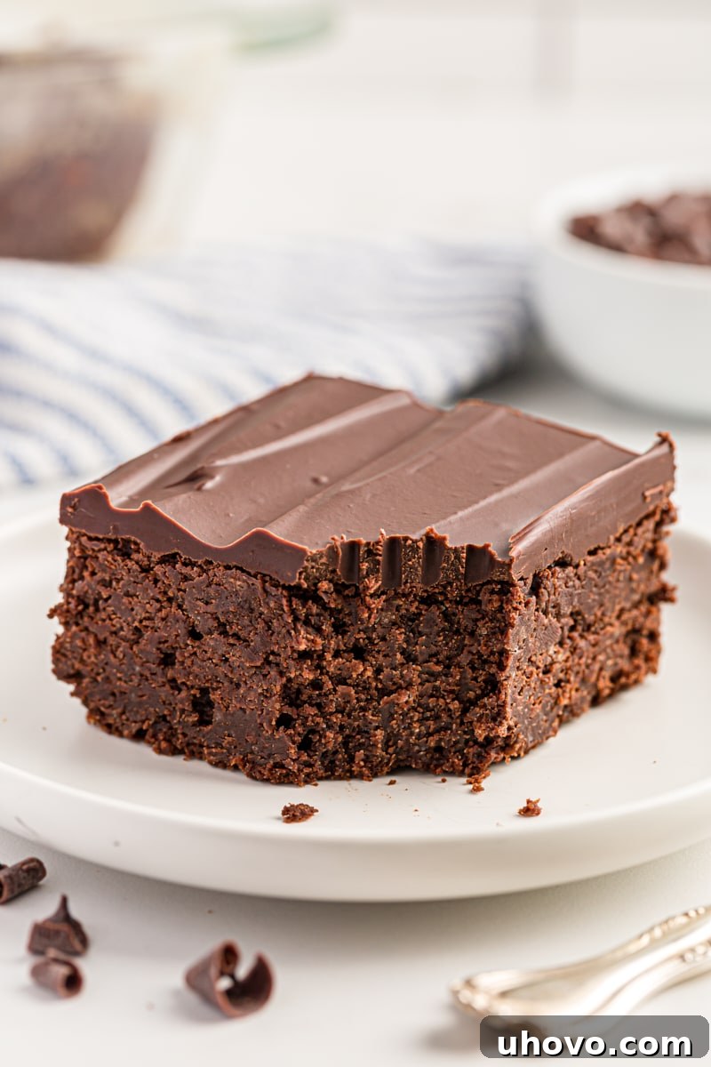 Chocolate mascarpone brownie on a white plate with a bite taken out of one corner, highlighting its fudgy interior.