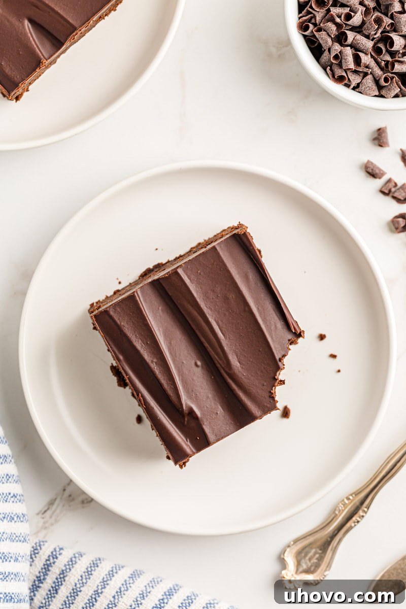 Close-up overhead view of a chocolate mascarpone brownie on a white plate with a corner missing, showing the rich interior.