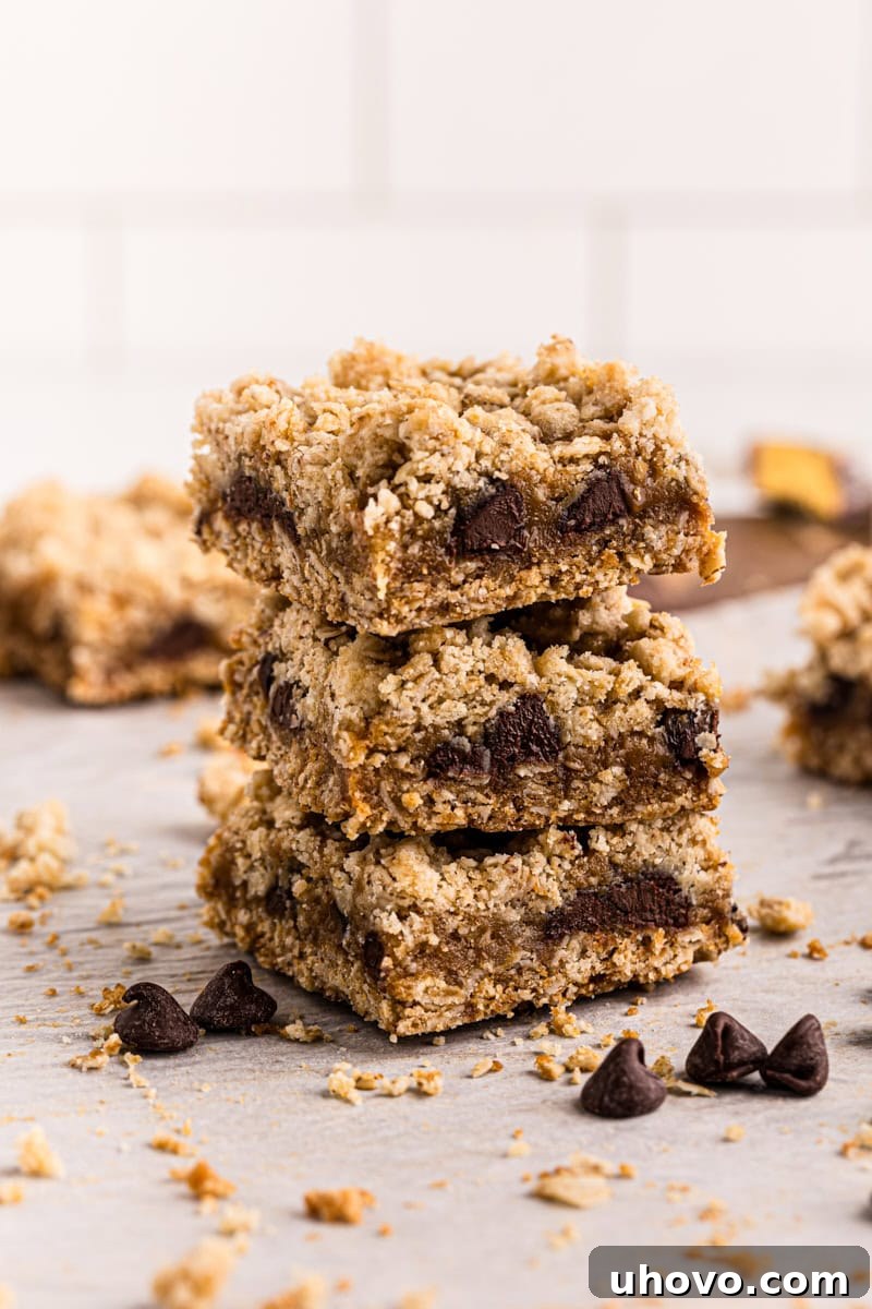 Stack of three homemade caramel oatmeal bars, showcasing gooey caramel and crumbly oat layers.