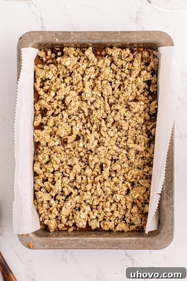 The assembled caramel oatmeal bars, topped with the remaining crumb mixture, ready for the final bake.