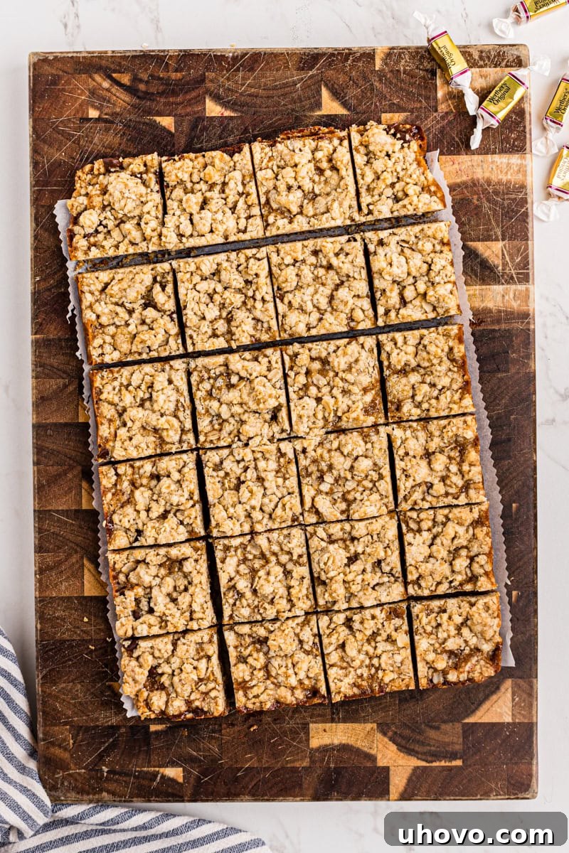 Caramel oatmeal bars cut into neat squares on a wooden cutting board, ready to serve.
