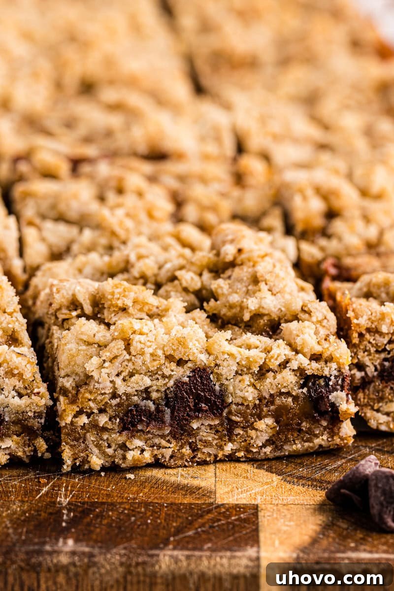 Several caramel oatmeal bars neatly arranged on a rustic wooden cutting board, highlighting their golden-brown top and rich filling.