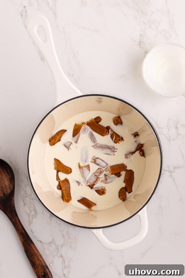 Soft caramels and heavy cream melting together in a saucepan over medium heat.