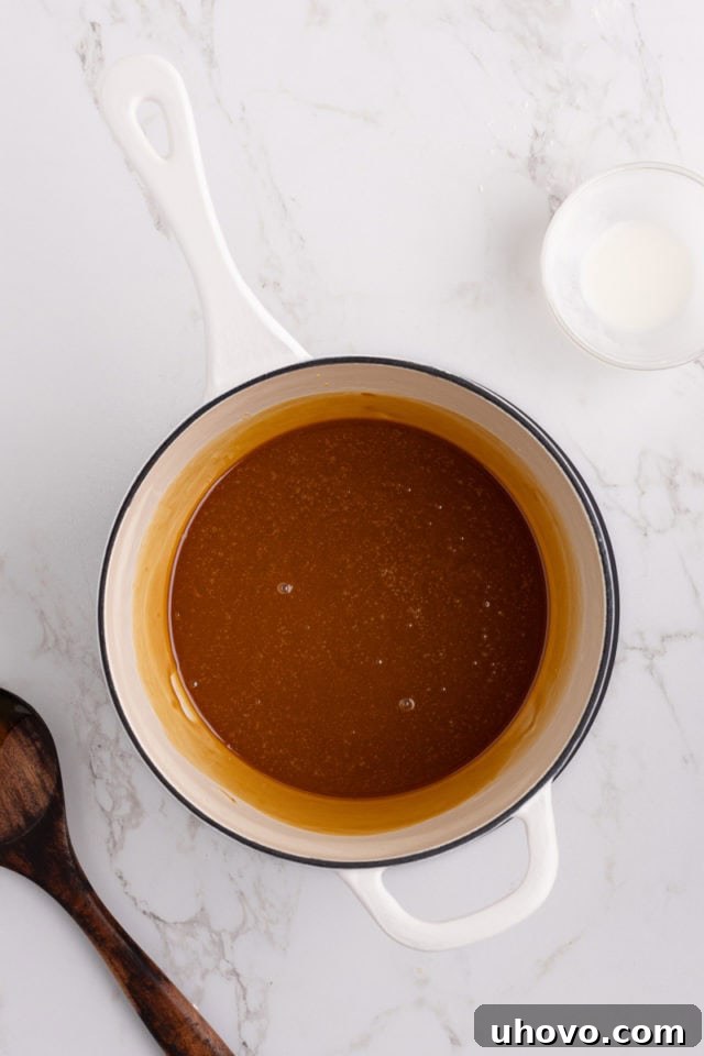 Smooth, glossy caramel filling bubbling gently in a saucepan.