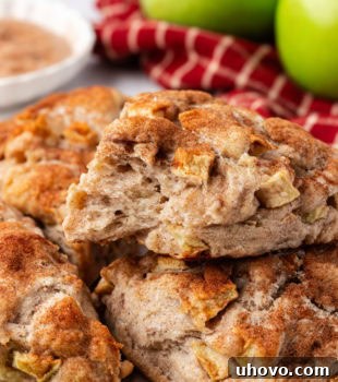 Flaky apple cinnamon scones stacked on a countertop, ready to eat.