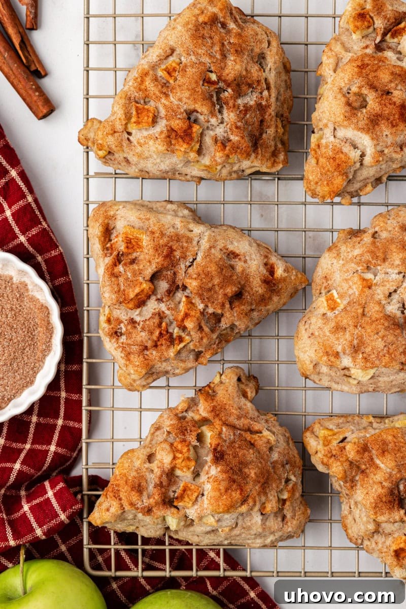 Warm apple cinnamon scones cooling on a wire rack after baking.