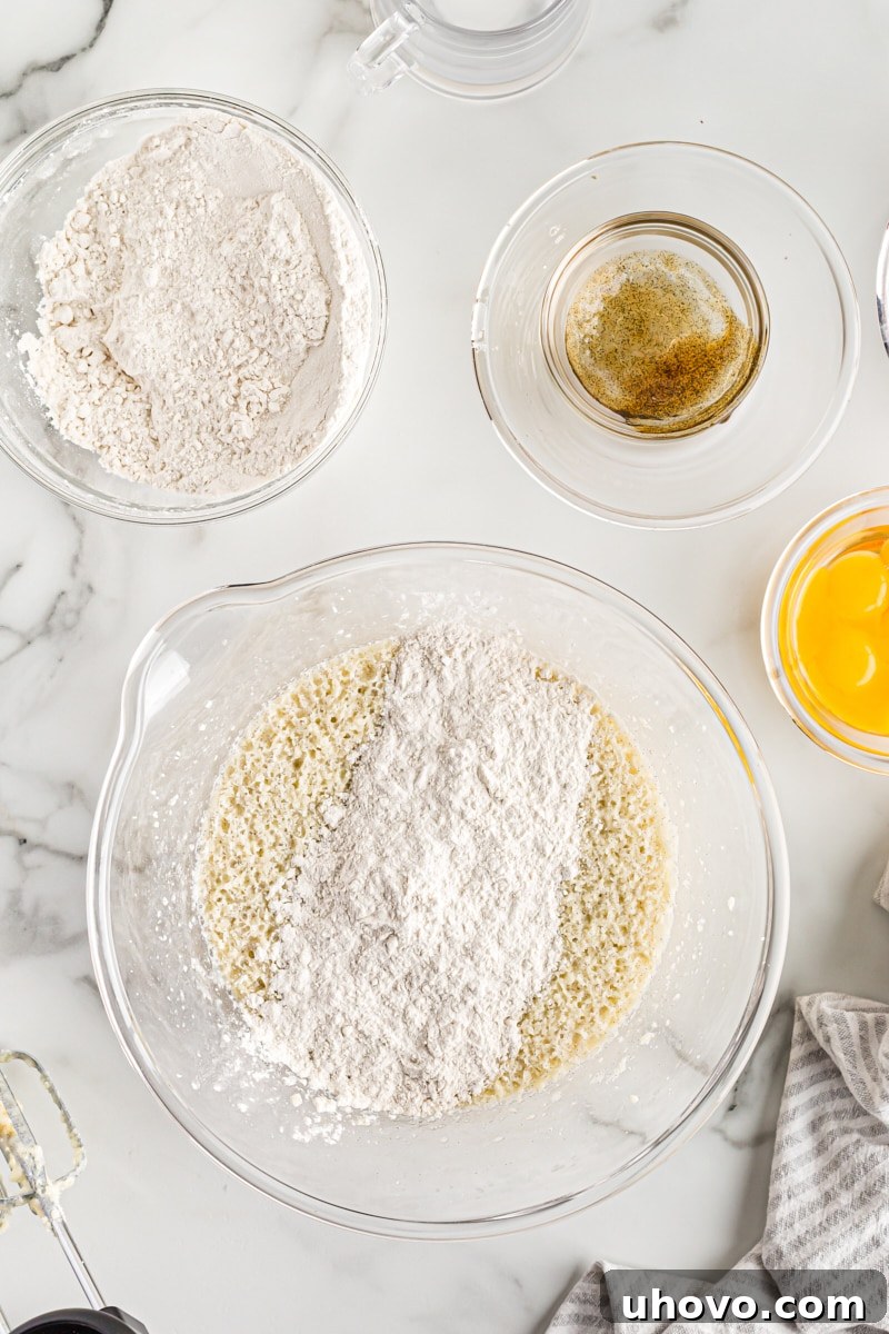 Adding the whisked dry ingredients into the bowl of wet ingredients for cupcake batter.