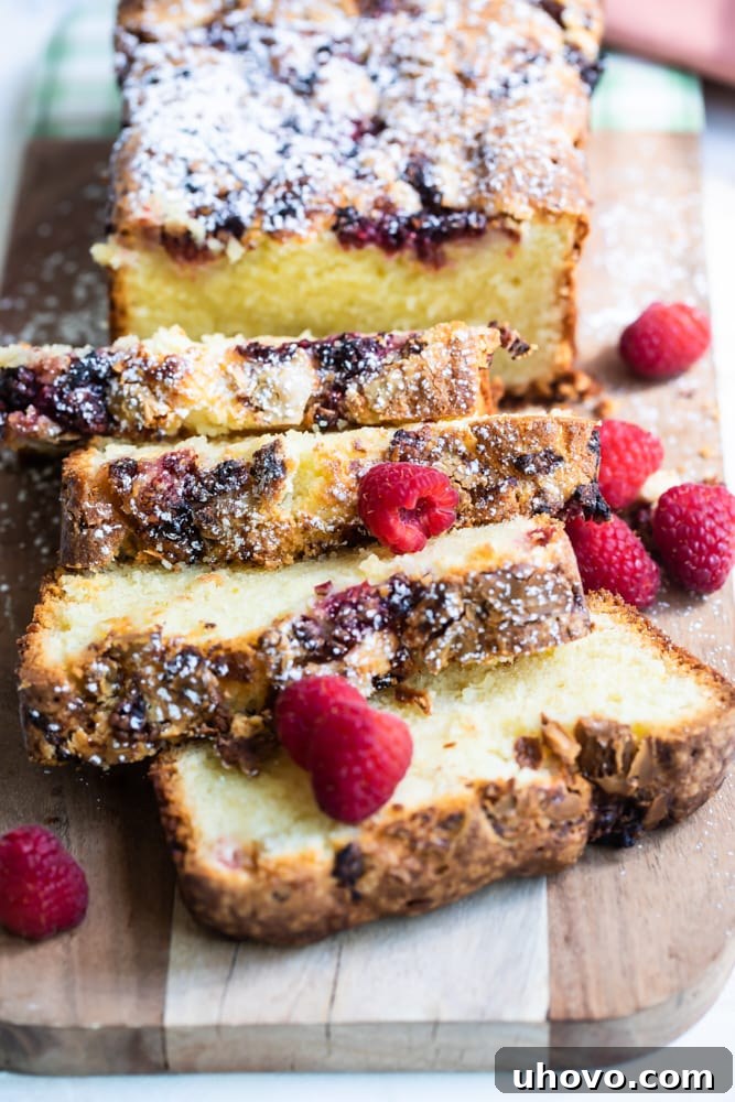 sliced Raspberry White Chocolate Almond Loaf on a wooden cutting board