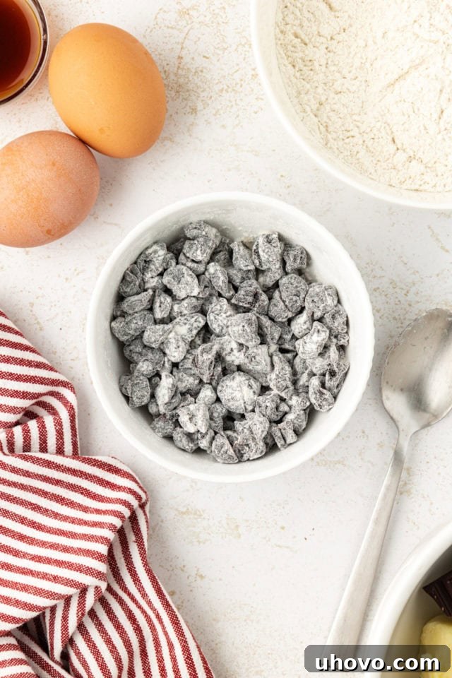 Chopped dried sour cherries coated lightly in flour in a bowl, preventing them from sinking in the batter.