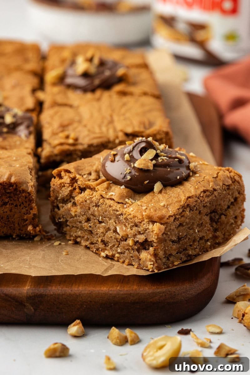Delectable hazelnut blondies arranged on a rustic wooden cutting board, showcasing their rich texture and golden brown edges.
