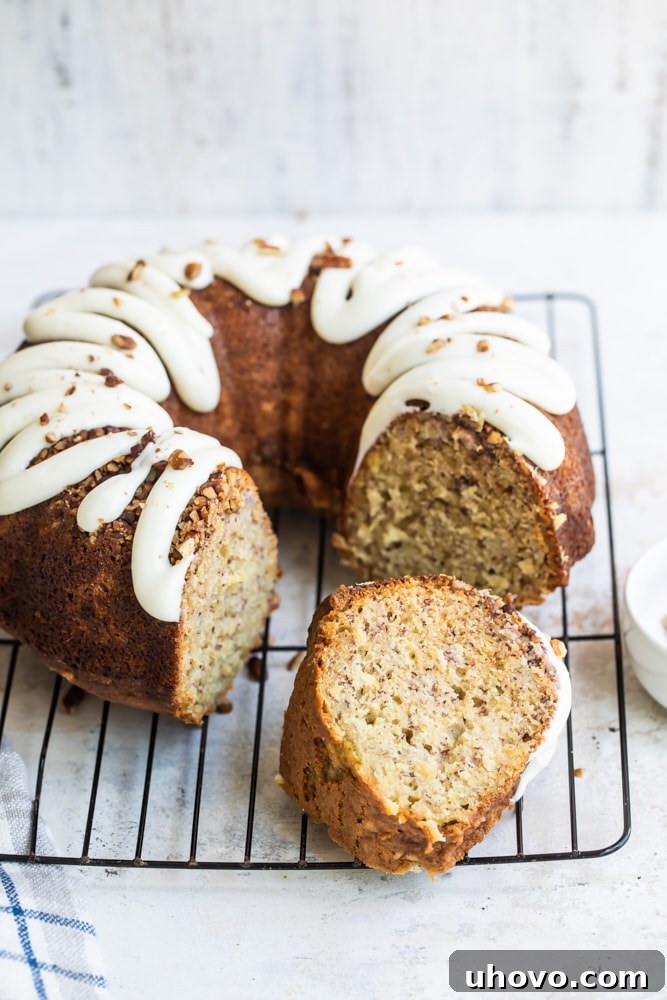 Hummingbird Bundt Cake on a wire rack with slice removed