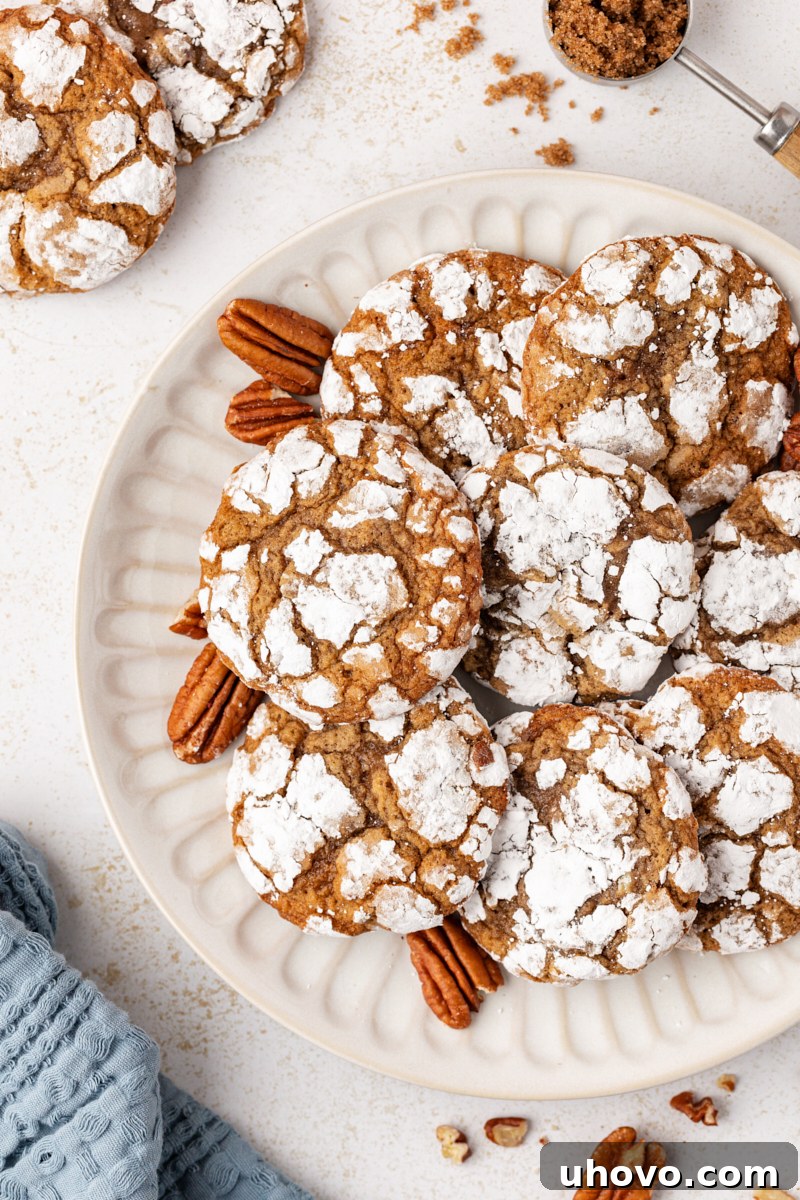 An overhead view of several brown sugar crinkle cookies arranged on a white plate, highlighting their distinct crinkled texture.