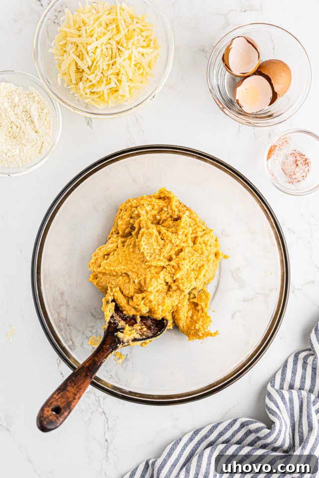 Overhead view of the gougères dough resting in a clear glass bowl, showcasing its smooth and glossy texture.