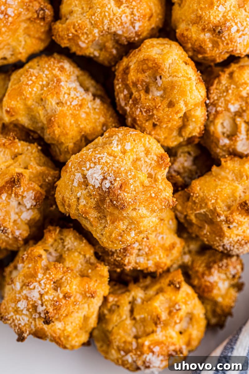 Overhead view of a generous pile of freshly baked, golden gougères, ready to be enjoyed.