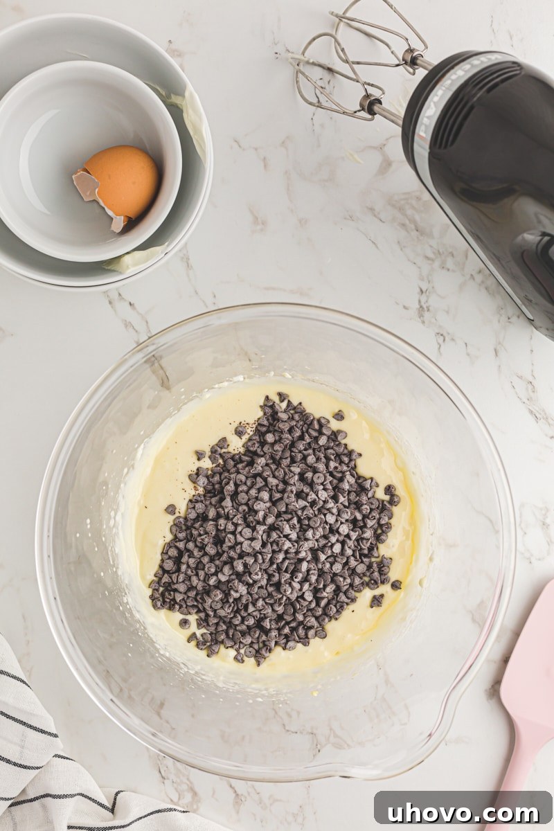 Adding chocolate chips to the cream cheese filling.