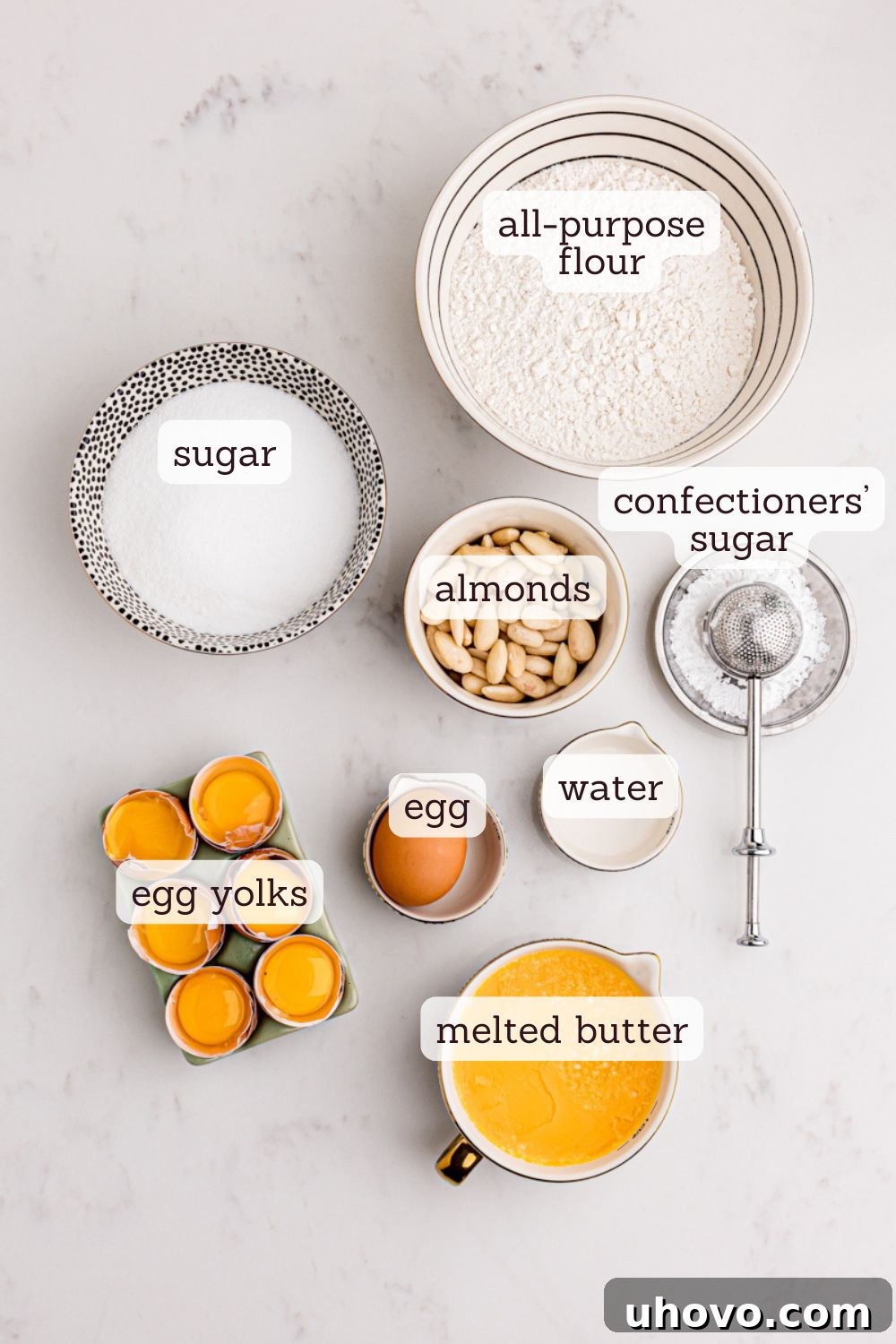 An inviting overhead view showcasing the simple yet essential ingredients for a delicious Almond Gâteau Breton, ready for baking.