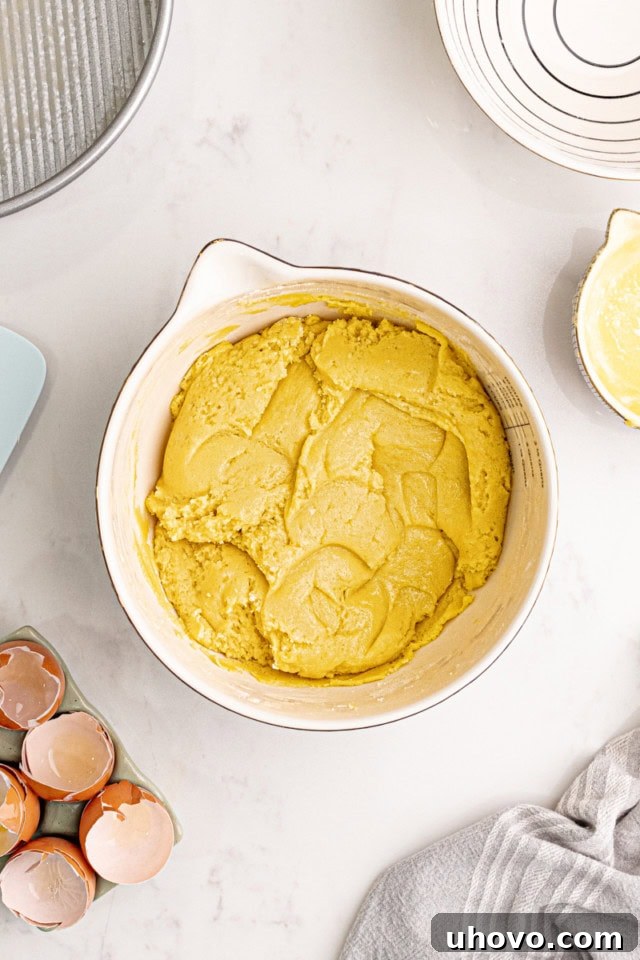 A top-down view of the thick, golden almond gâteau Breton batter in a mixing bowl, perfectly combined and ready for the next step.