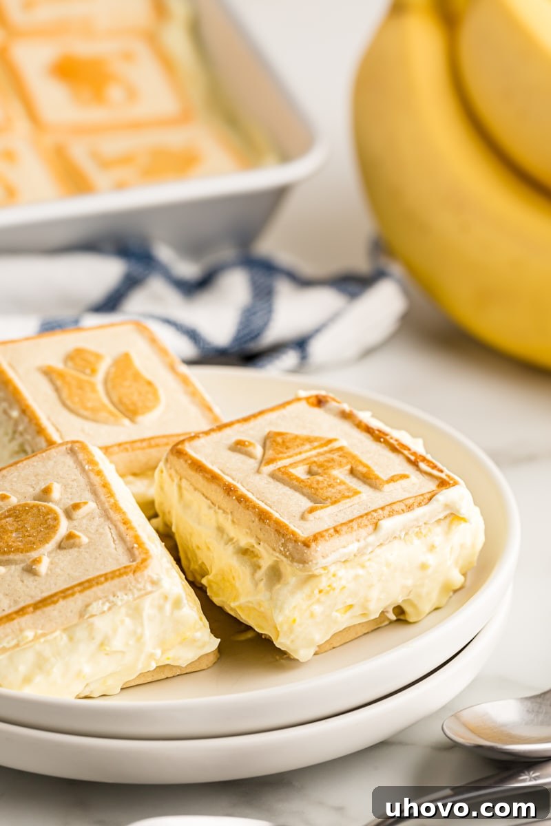Squares of banana pudding served on stacked white plates, ready to be enjoyed.