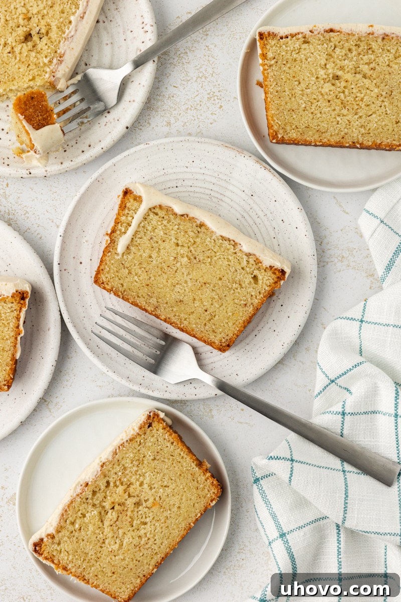 Overhead view of several slices of brown butter pound cake artfully arranged on white plates, ready to be served.