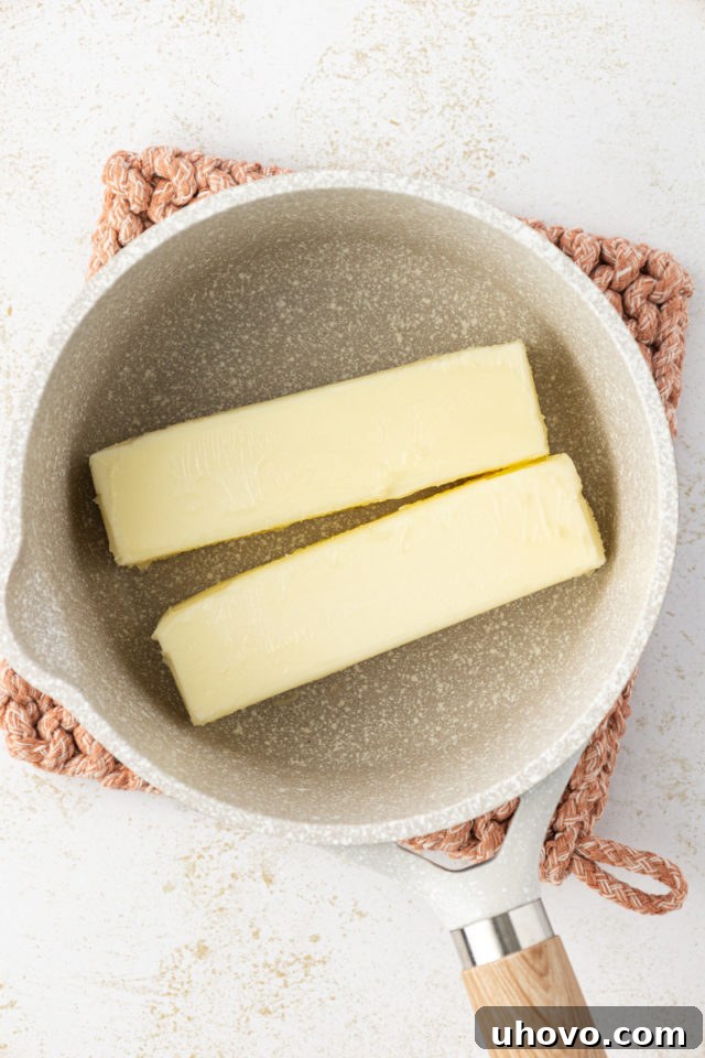 Overhead view of butter cubes in a saucepan, ready for browning.