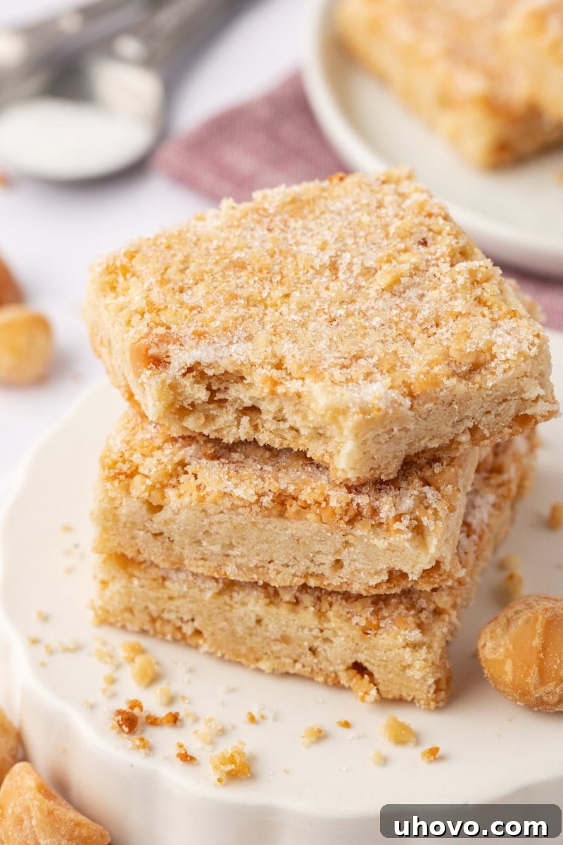 stack of three macadamia shortbread with a bite missing from the top cookie