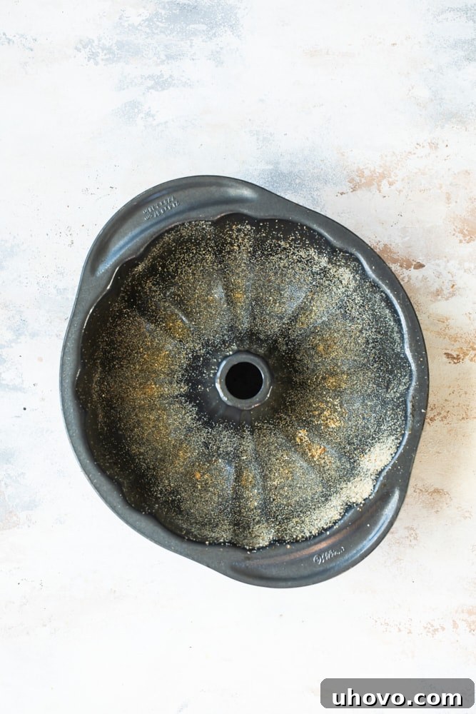 Overhead view of bundt cake pan greased and dusted with breadcrumbs