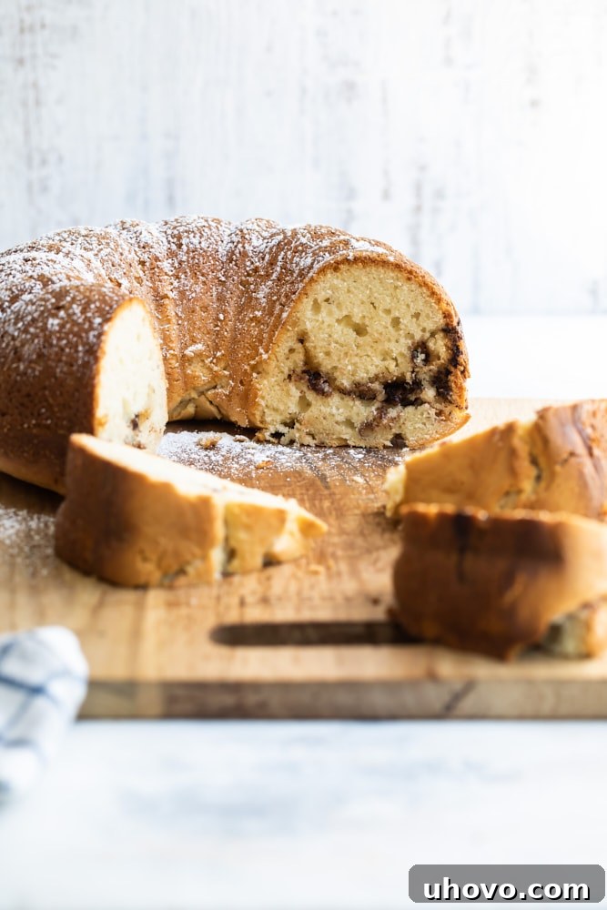Half of a Nutella bundt cake on cutting board with pieces of cake in foreground