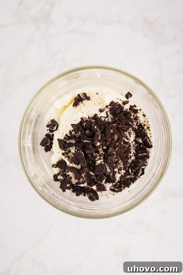 overhead view of Oreo cookie pieces added to no-bake cheesecake filling