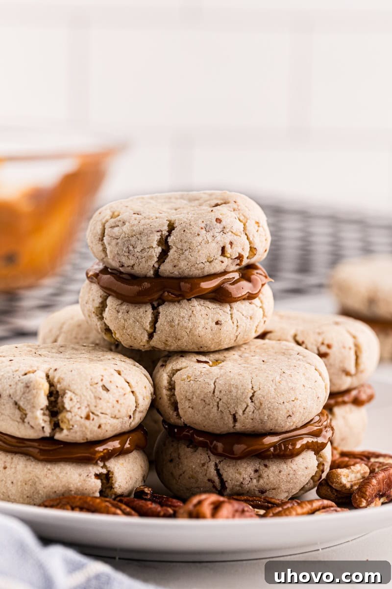 A neat stack of dulce de leche cream cheese shortbread sandwiches presented on a plate, highlighting their inviting layers.
