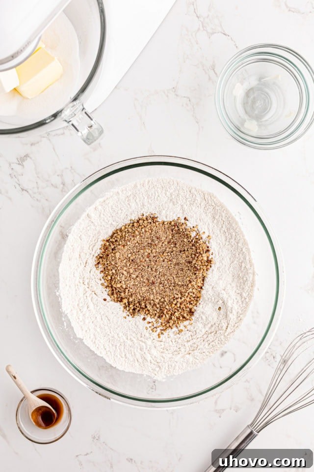 Pecans being added to a bowl of flour and salt, ready for mixing.