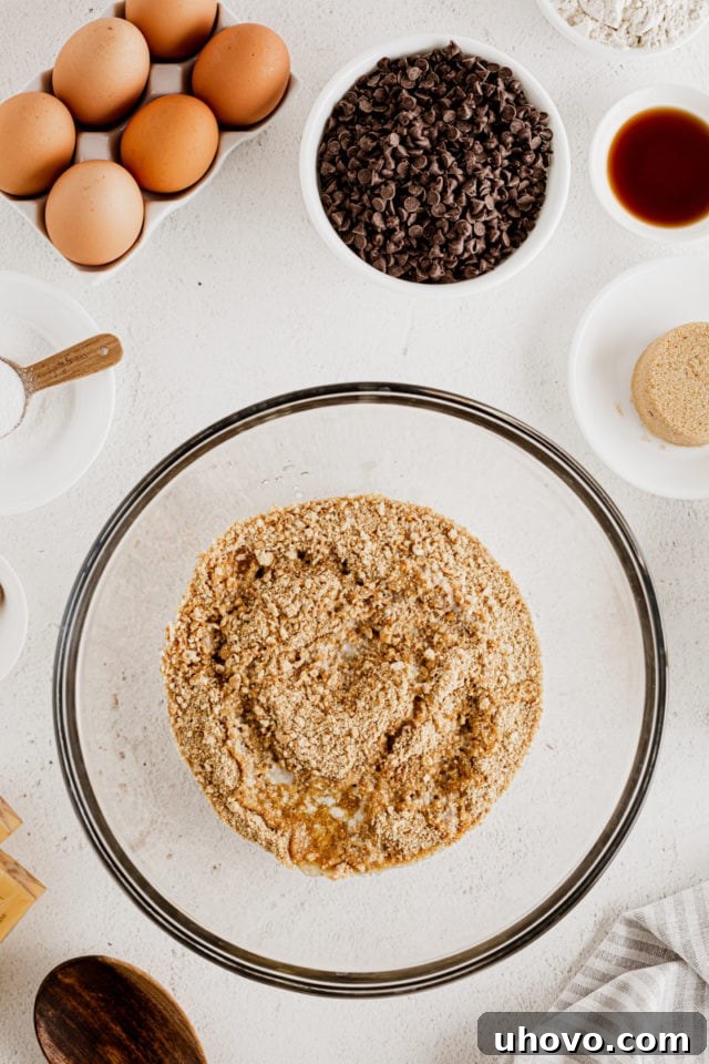 Overhead view of cheesecake bar crust in glass mixing bowl
