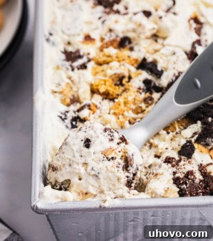 All the Cookies Ice Cream perfectly set in a metal loaf pan, with a scoop ready in the corner for serving.
