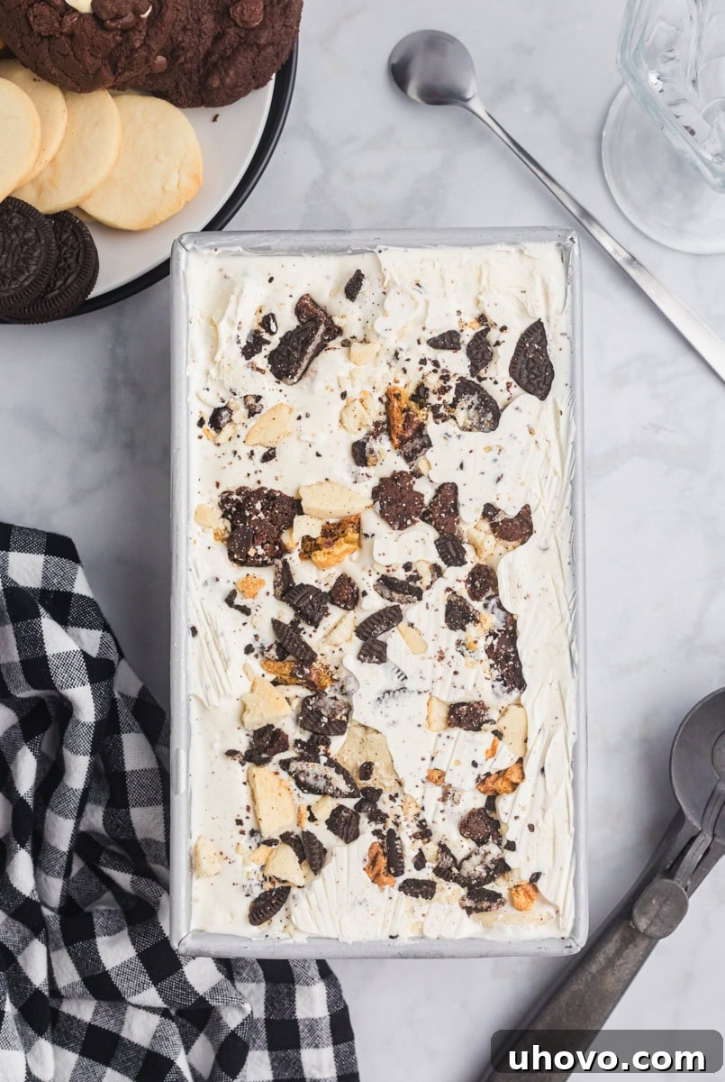 Overhead view of the finished All the Cookies Ice Cream, perfectly set in a metal loaf pan on a elegant marble surface.