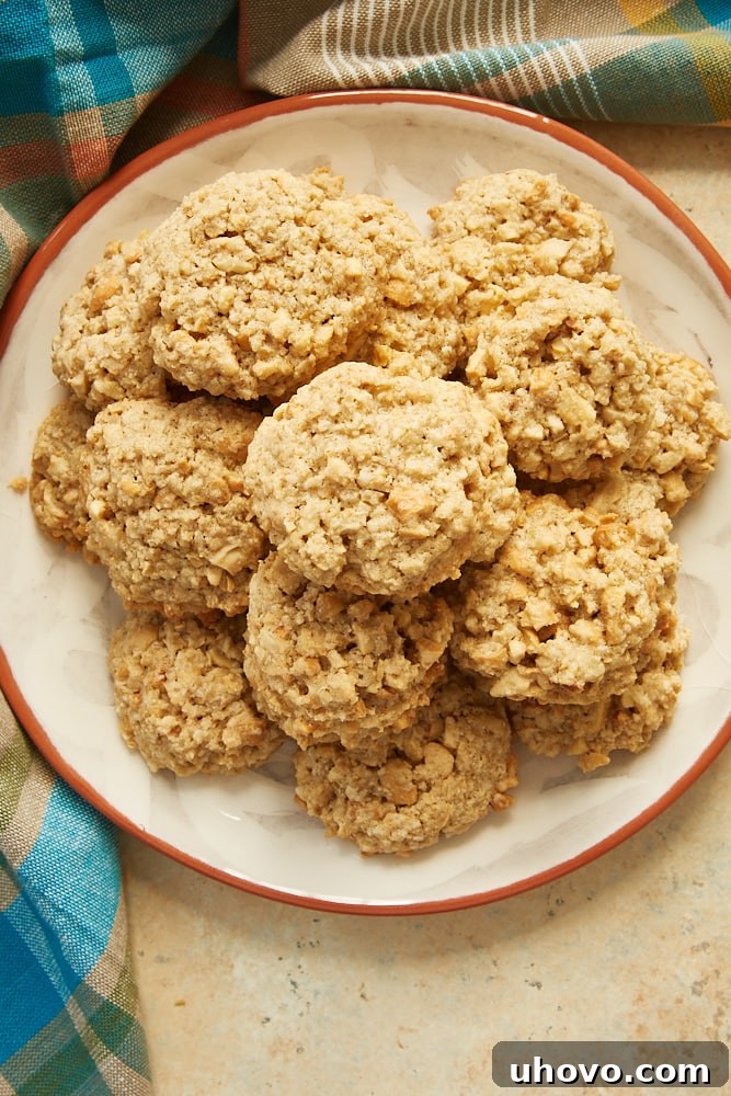 More Salted Cashew Crunch Cookies arranged on an orange-rimmed plate, ready to be enjoyed as a sweet and salty snack.