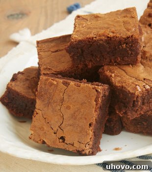 A pyramid-shaped stack of Milk Chocolate Brownies on a plate.