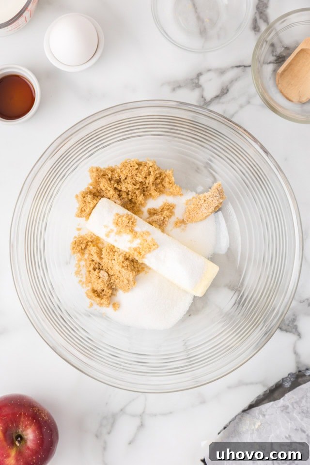 overhead view of butter, sugar, and brown sugar in a glass mixing bowl