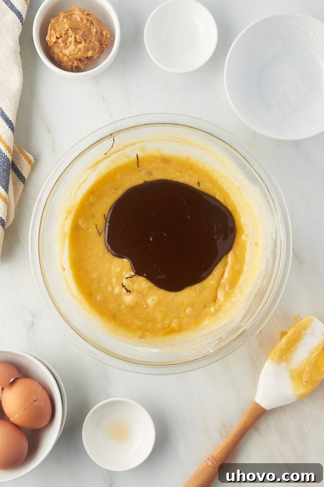 Overhead view of chocolate added to brownie batter