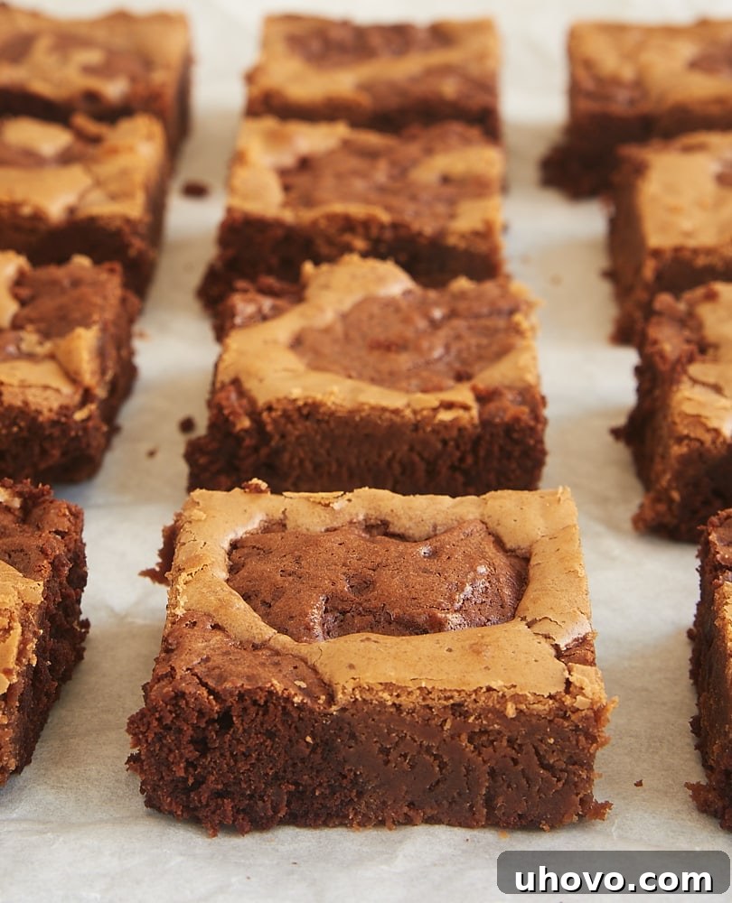 Dolloping dark and milk chocolate brownie batters into a pan, creating the foundation for beautiful marbled brownies.