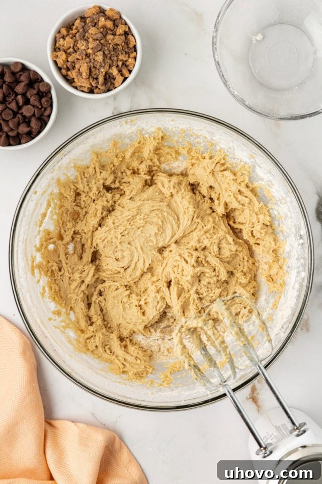 Overhead view of the blondie batter in a glass mixing bowl, showing it has been mixed just until combined, with a few small streaks of flour still visible, indicating proper mixing technique.