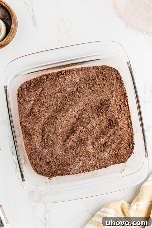 Overhead view of the chocolate cobbler with the dry sugar-cocoa mixture sprinkled over the batter, before adding hot water.