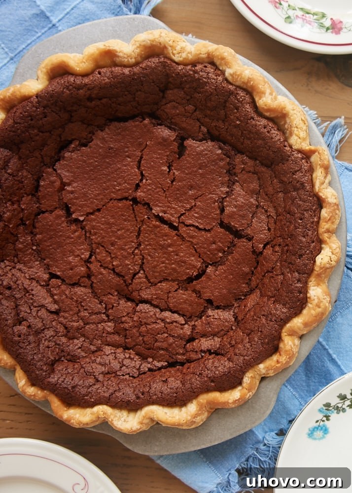 Whole chocolate chess pie in a rustic ceramic pie dish, ready for serving