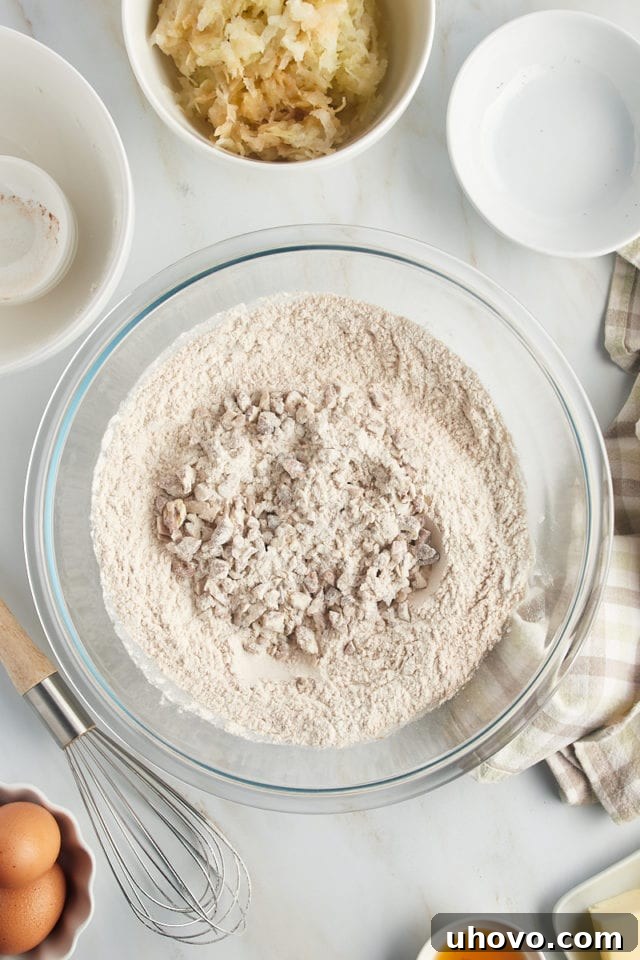 Overhead view of nuts added to bowl of dry bread ingredients