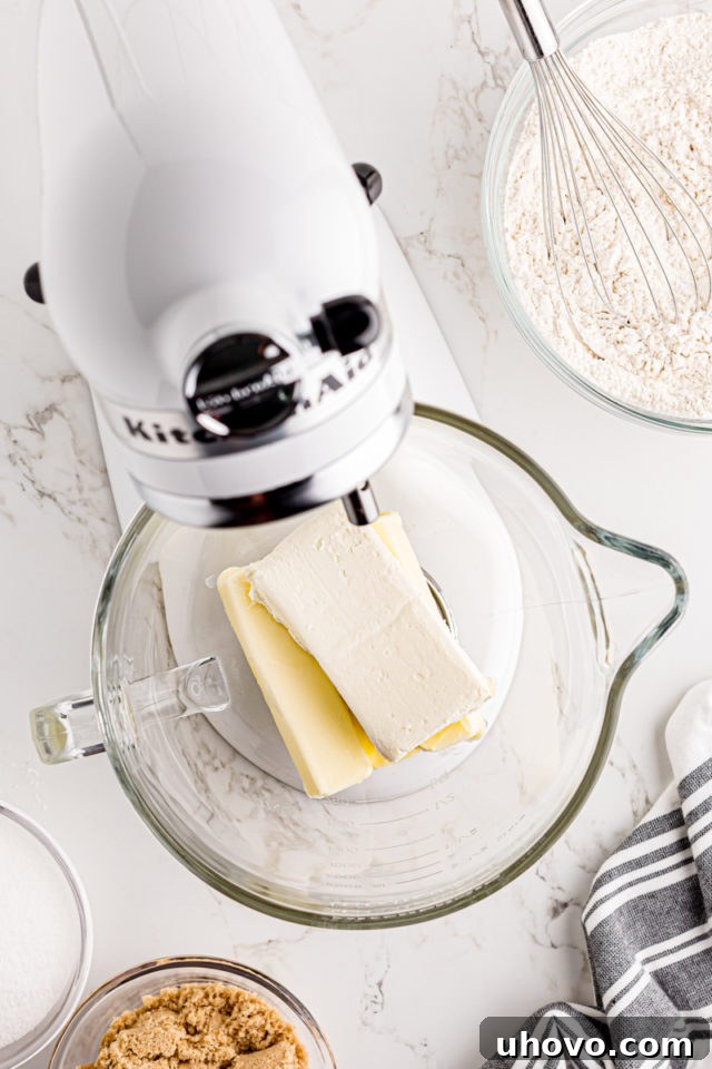 Overhead shot of softened butter and cream cheese in the bowl of a stand mixer, perfectly prepared for creaming.