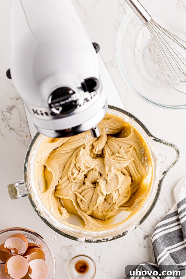 The fully mixed cream cheese pound cake batter, smooth and ready for baking, resting in the bowl of a stand mixer.